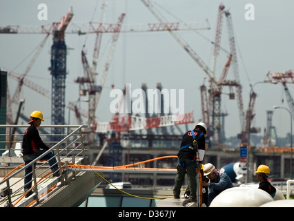 Arbeitnehmer auf dem Singapore Flyer als Konstruktion im Hintergrund auf dem LV Sands Corp. Marina Bay Sands Casino weiter Stockfoto