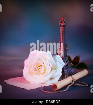 Bild der schönen Retro-Stil Stillleben über blaue Grunge Hintergrund, weiße frische rose Blume, kleine dekorative Eiffelturm Stockfoto