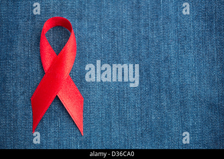 Rotes Band für Aids-Aufklärung auf denim Stockfoto