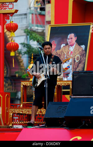 Bangkok, Thailand, 11. Februar 2013.  Thai Gitarrist hält die Party am laufen w / Rama 9, der siamesische König hinter ihm auf dem Chinese New Year Festival Bangkok Credit: Kraig Lieb / Alamy Live News Stockfoto