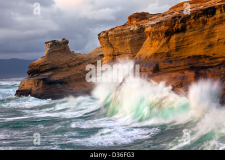 OR01019-00... OREGON - Surf hämmerte die Sandsteinfelsen an einem stürmischen Tag am Cape Kiwanda State Park. Stockfoto