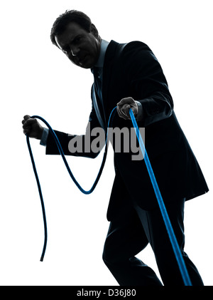 ein Business-Mann zieht ein Seil im Silhouette Studio isoliert auf weißem Hintergrund Stockfoto