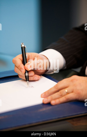 Geschäftsmann Unterzeichnung Vertrag am Tisch. Stockfoto