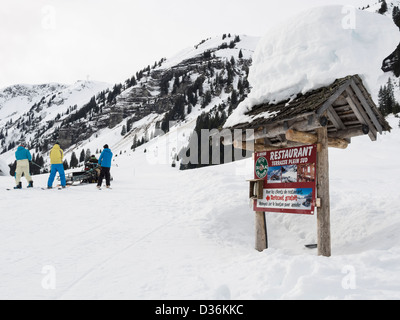 Melden Sie für Gite du Lac de Gers Restaurant neben Les Cascades Skipiste mit Skifahrer geschleppt durch kostenlose Ski-Doo im Le Grand Massif Stockfoto