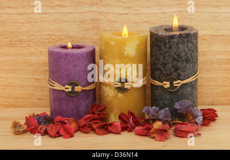 Drei brennende Feng Shui Kerzen und Potpourri aus Holz im Hintergrund Stockfoto