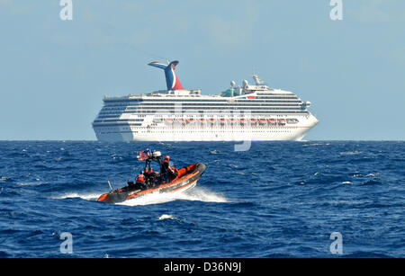 United States Coast Guard kleine Bootscrew Patrouillen in der Nähe der Kreuzfahrt Schiff Carnival Triumph die Macht nach einem Triebwerksbrand Zimmer verloren 11. Februar 2013 in den Golf von Mexiko. Stockfoto