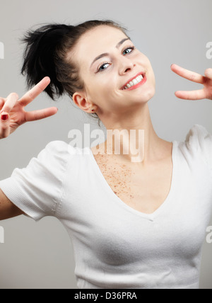 Porträt einer schönen jungen Frau lächelnd isoliert auf grau Stockfoto