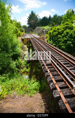 Blick entlang der Eisenbahn eine Arbeit verfolgen auf einer alten Trestle-Brücke über einen Fluss. Northland, Nordinsel, Neuseeland. Stockfoto