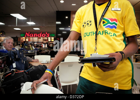 Ein Kellner an Oliver Tambo International Airport am Morgen des Bafana Bafanas Gruppe A Zusammenstoß mit Uruguay Stockfoto