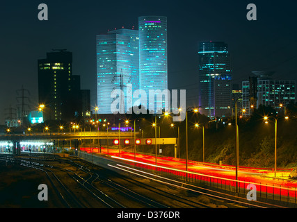 Nachtansicht von Tel Aviv in der Innenstadt, beleuchtet Azrieli Towers und Lichtspuren auf Ayalon Highway. Stockfoto