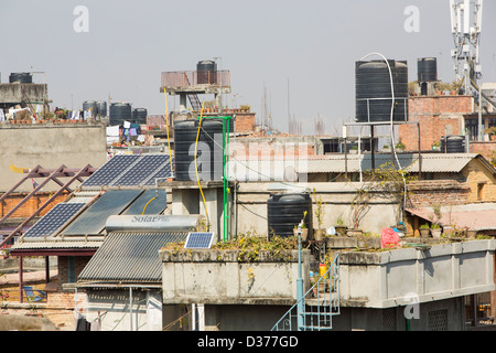 Thermische Sonnenkollektoren für die Warmwasserbereitung mit solar Photovoltaik-Panels auf den Dächern von Kathmandu, Nepal. Stockfoto