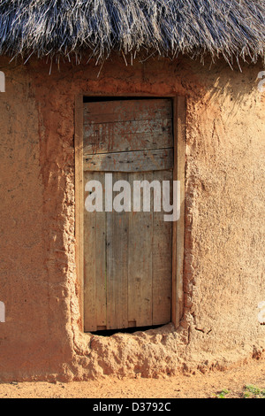 Einfache Lehmhütte mit einer Holztür Stockfoto