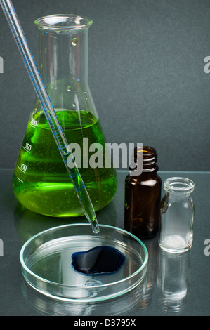 Labor-Becher mit Grünfärbung flüssige Stoffe und Labor Pipette gefüllt. Dunklen Hintergrund Stockfoto
