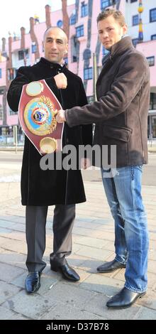 Magdeburg, Deutschland. 12. Februar 2013. Der amtierende WBO Super-Mittelgewicht World Champion Arthur Abraham (L) und sein Herausforderer Robert Stieglitz stellen bei einem Fototermin vor dem Hundertwasserhaus in Magdeburg, Deutschland, 12. Februar 2013. Abraham wird am 23. März 2013 Stieglitz für den WBO-Weltmeistertitel kämpfen. Foto: JENS WOLF/Dpa/Alamy Live News Stockfoto