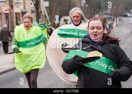 Weibliche Konkurrenz in Fancy Dress, teil zu nehmen, die in den traditionellen, jährlichen Ilkley Rotary Pancake Race - The Grove, Ilkley, West Yorkshire, UK. Stockfoto