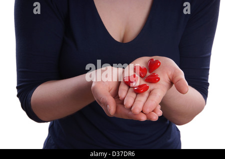 Frau präsentiert rote Keramik Herzen in ihren Händen Stockfoto