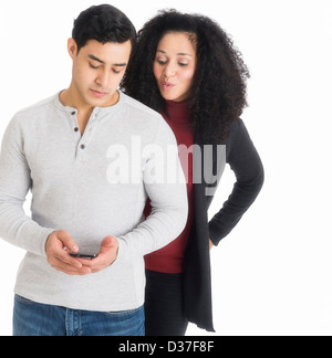 Studioaufnahme des jungen Paares Blick auf Handy Stockfoto
