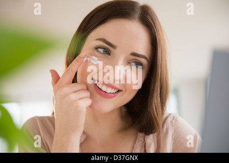 USA, New Jersey, Jersey City, junge Frau Gesichtscreme auftragen Stockfoto