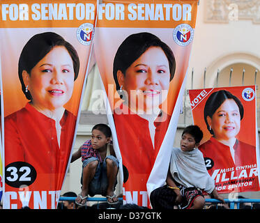 Manila, Philippinen. 12. Februar 2013. Philippinische Kinder sind während einer Kundgebung der Verkündigung der philippinische Präsident Benigno Aquino III 'Team PNoy' Ticket für ihren Schiefer in den Kongress- und lokalen Wahlen im Mai in Manila, 12. Februar 2013 neben Plakaten gesehen. Senatorische Kandidaten für den Mai 13 Zwischenwahlen startete ihre Kampagnen als dem offiziellen Beginn des Wahlkampfs für nationale Positionen begonnen. Die Kampagne-Saison ist vom 12. Februar bis 11. Mai 2013 geplant. Bildnachweis: Ezra Acayan / Alamy Live News Stockfoto