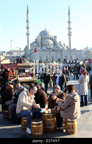 Leute, die Essen an Imbissständen von Galata-Brücke, mit Yeni Camii (Moschee) im Hintergrund, Istanbul, Türkei. Stockfoto