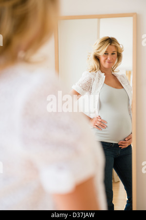 Schwangere Frau in Spiegel Stockfoto