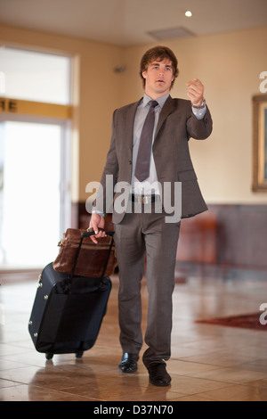 Geschäftsmann rollenden Gepäck in der lobby Stockfoto
