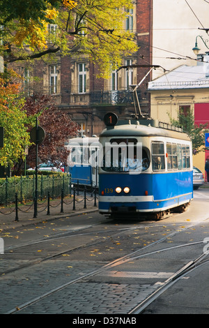 Die Straßenbahn ist in Bewegung auf der Straße, Herbst-farbige Bäume, die Herbstsonne Stockfoto