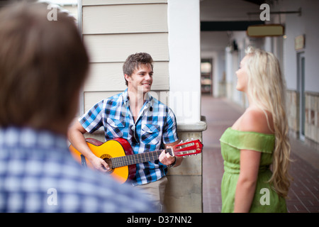 Mann Gitarre spielen für Freundin Stockfoto