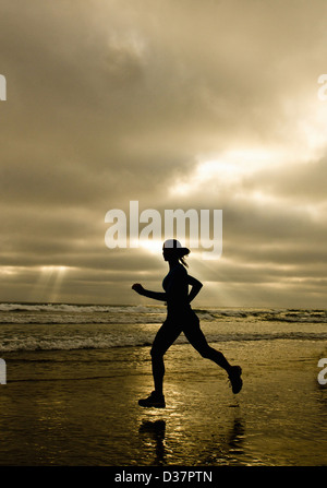Frau laufen am Strand Stockfoto