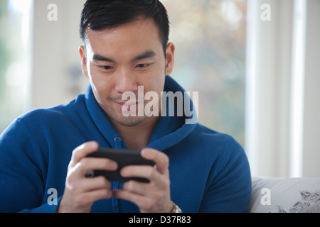 Mann mit Handy auf sofa Stockfoto