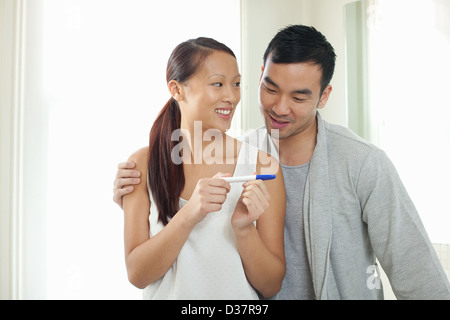 Paar unter Schwangerschaftstest im Badezimmer Stockfoto