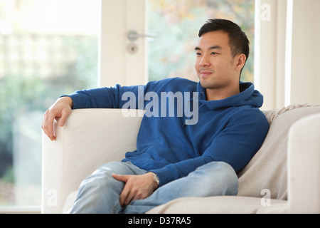 Lächelnder Mann auf sofa Stockfoto