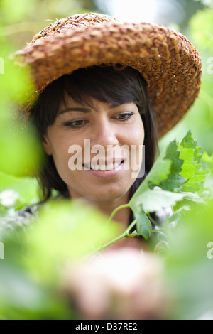 Lächelnde Frau in hohen Pflanzen stehen Stockfoto