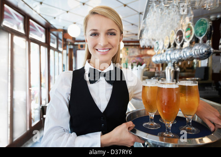 Dänemark, Aarhus, Porträt der jungen Frau mit Tablett mit Biergläser Stockfoto