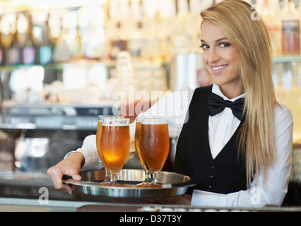 Dänemark, Aarhus, Porträt der jungen Frau mit Tablett mit Biergläser Stockfoto