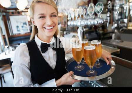 Dänemark, Aarhus, Porträt der jungen Frau mit Tablett mit Biergläser Stockfoto