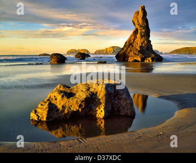 Ebbe und Sonnenuntergang mit vulkanischen Felsen am Strand von Bandon stapeln. Oregon Stockfoto