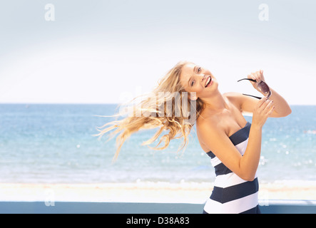Frau wirft ihr Haar am Strand Stockfoto