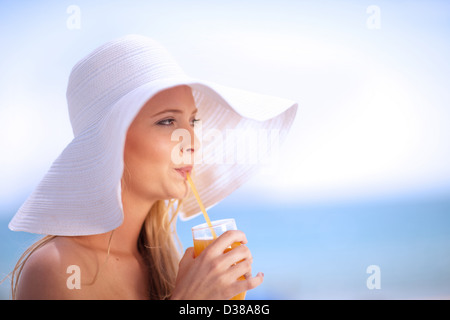 Frau in Schlapphut Saft zu trinken Stockfoto