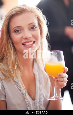 Frau mit Orangensaft im café Stockfoto