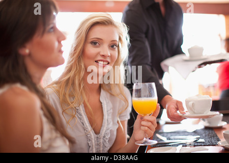 Frau mit Orangensaft im café Stockfoto