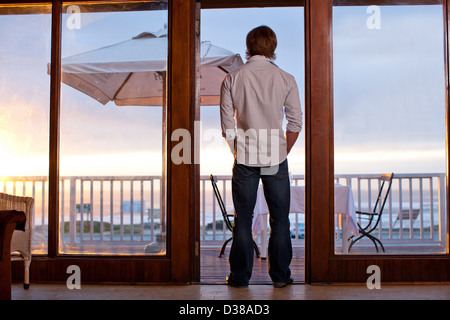Mann steht im Tor der Terrasse