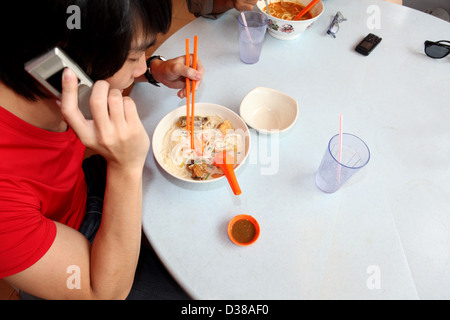 Mann am Handy sprechen und Essen Stockfoto