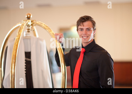 Porter mit Gepäckwagen in Hotellobby Stockfoto