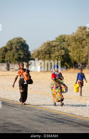 Traditionelle Frau zu Fuß auf der Straße in der Nähe von Rundu Dorf in Namibia Stockfoto