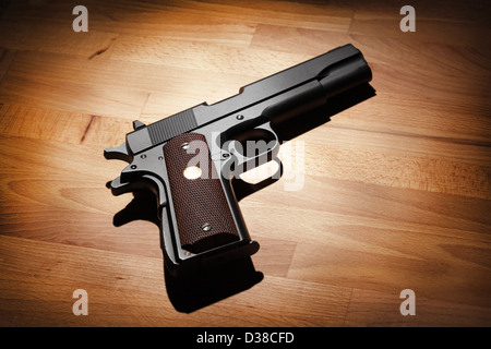 M1911 halbautomatische Kaliber.45 Pistole auf eine Holzoberfläche. Studio gedreht Stockfoto