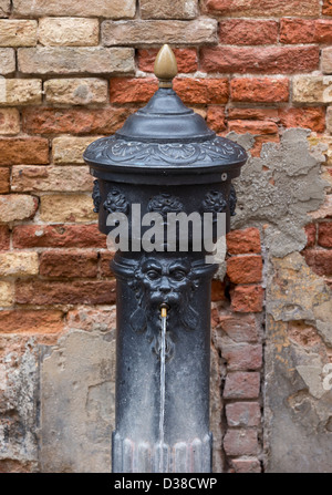 Gusseisen öffentlichen Brunnen mit der Figur eines Löwen Kopf sprudelt Wasser aus seinem Mund in Venedig Stockfoto