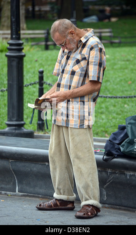 Mann liest im Washington Square Park in Greenwich Village, New York City Stockfoto