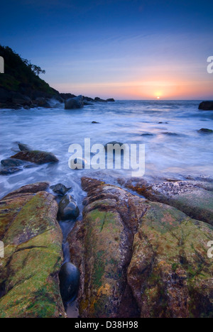 Wellen über die Felsen am Strand Stockfoto