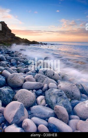 Wellen am felsigen Strand abwaschen Stockfoto